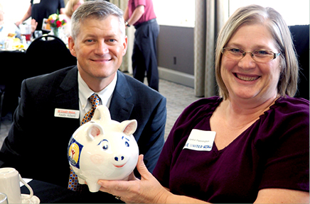 Two people holding piggy bank